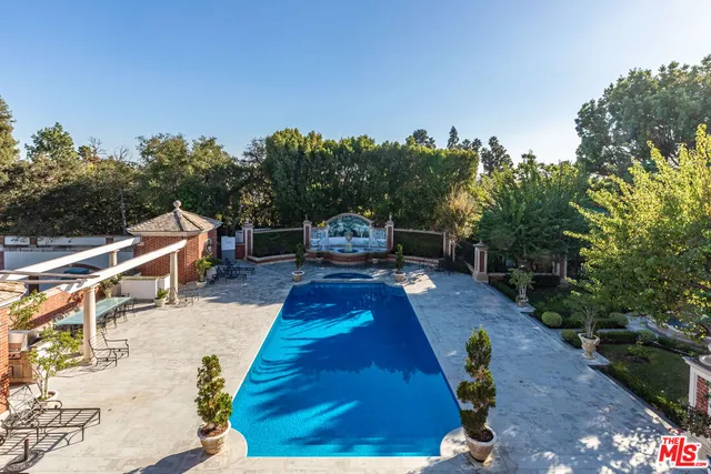 a view of a house with a big yard and large trees