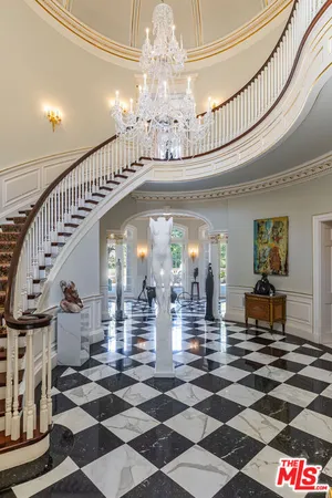 a view of a hallway with dining room and chandelier