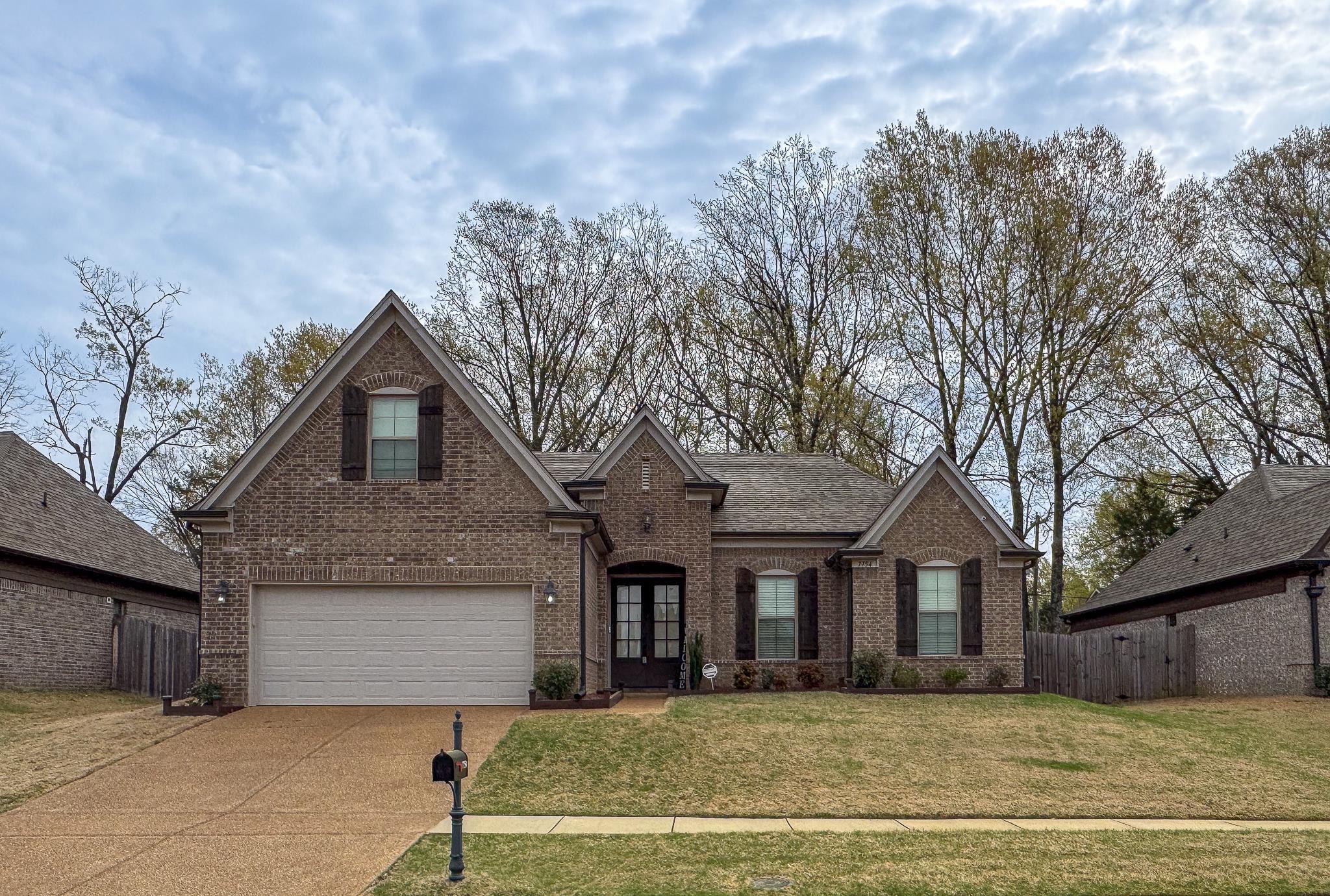 7754 Shadowcrest Road Memphis, TN 38125 - Photo 1 of 27 Traditional home featuring fence, a garage, brick siding, a front lawn, and driveway