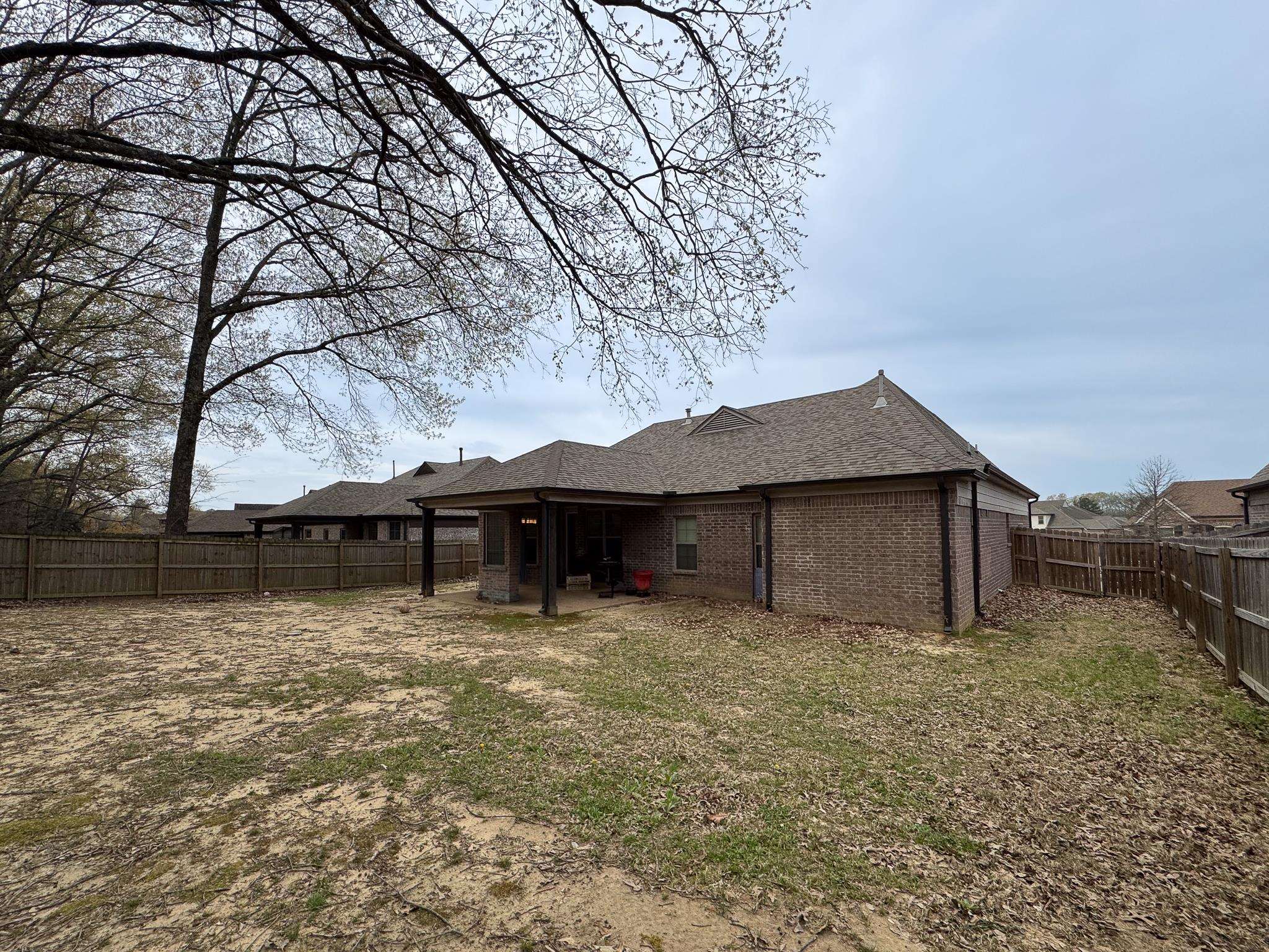 7754 Shadowcrest Road Memphis, TN 38125 - Photo 27 of 27 Back of house with brick siding, a fenced backyard, and roof with shingles