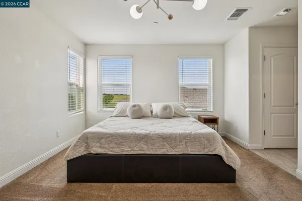a large bed sitting in a bedroom next to a window