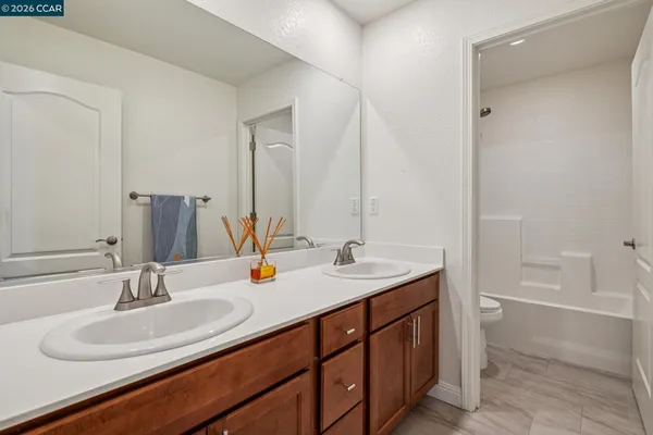 a bathroom with a sink double vanity granite tub shower and a mirror