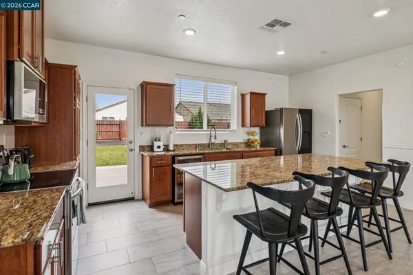 a kitchen with refrigerator and chairs
