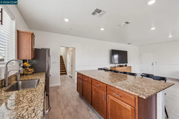 a kitchen with stainless steel appliances granite countertop a sink stove and refrigerator
