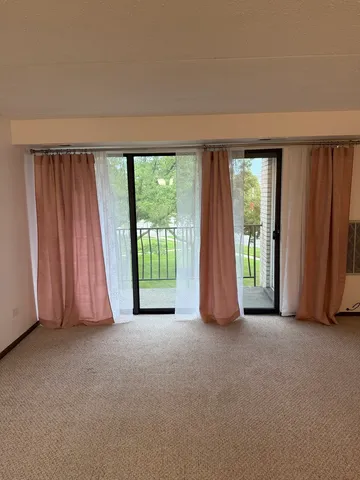 an empty room with large windows and a balcony