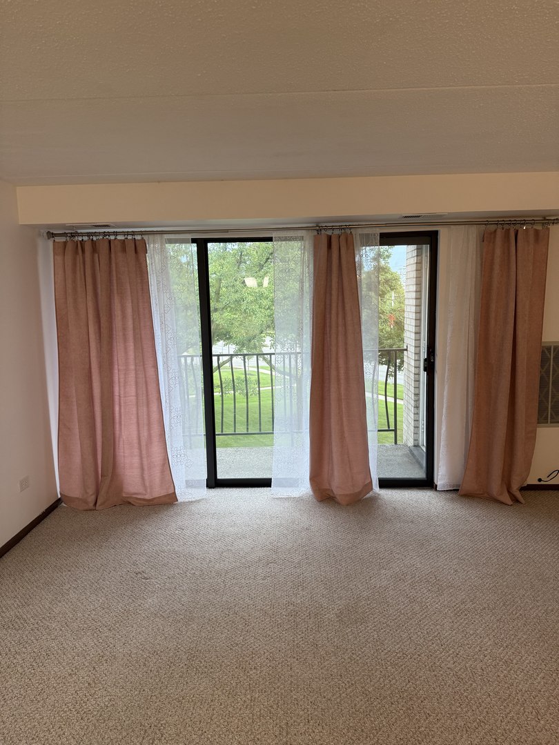 6950 West Forest Preserve Drive, Unit 202 Norridge, IL 60706 - Photo 5 of 15 an empty room with large windows and a balcony