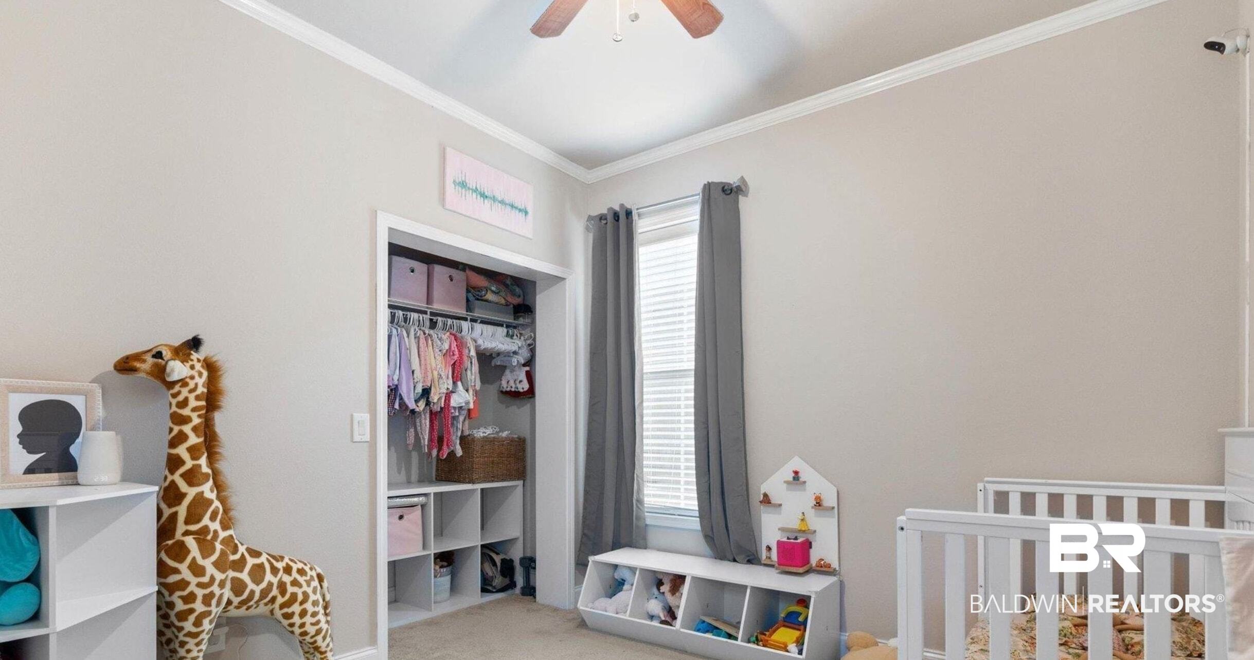 25806 Pollard Road, Unit 203 Daphne, AL 36526 - Photo 11 of 14 Bedroom featuring light carpet, ornamental molding, a crib, ceiling fan, and a closet