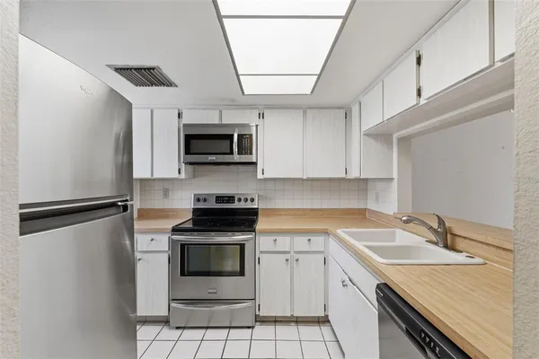 a kitchen with granite countertop a sink stainless steel appliances and cabinets