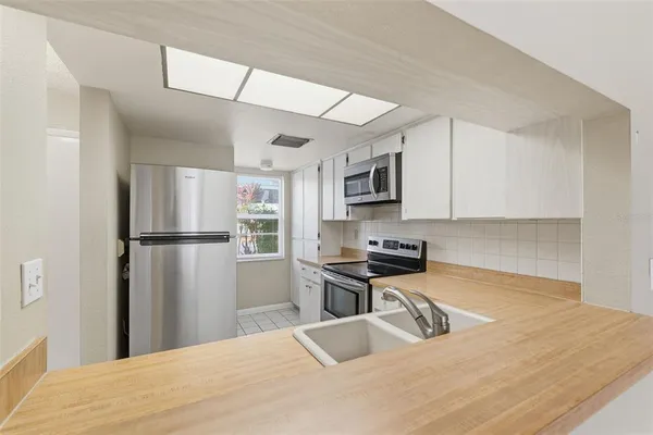 a kitchen with stainless steel appliances granite countertop a sink refrigerator and cabinets