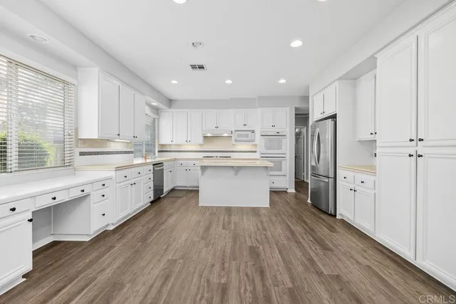 a kitchen with stainless steel appliances a refrigerator sink and cabinets