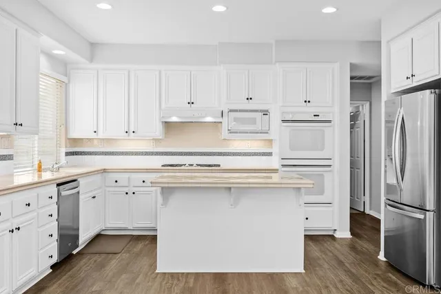 a kitchen with white cabinets and stainless steel appliances