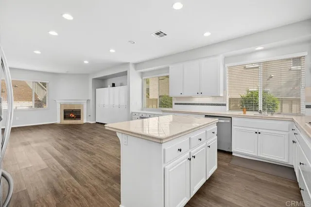a kitchen with granite countertop white cabinets and white appliances
