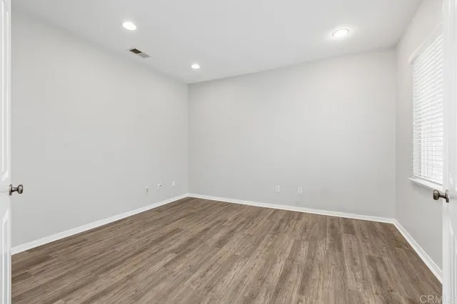 a view of room with wooden floor and windows