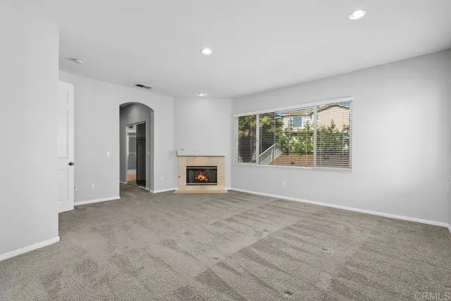 an empty room with fireplace and windows