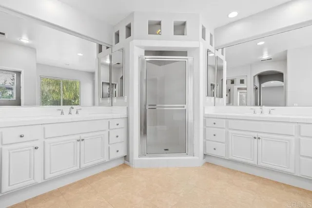 a spacious bathroom with a granite countertop sink mirror and shower