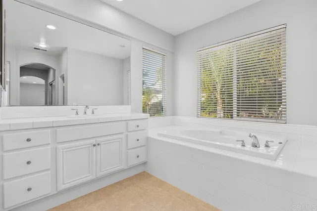 a bathroom with double vanity and a large mirror