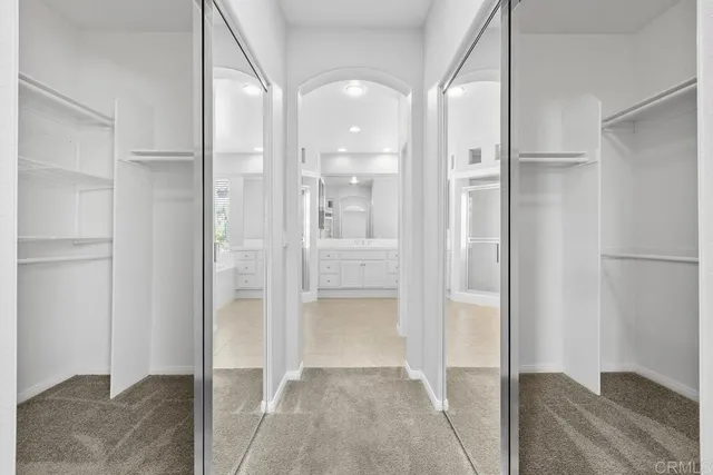 a view of a hallway with wooden floor and a bathroom