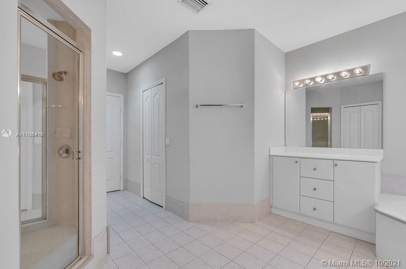 4131 Southwest 154th Court Miami, FL 33185 - Photo 25 of 36 a spacious bathroom with a mirror and a shower