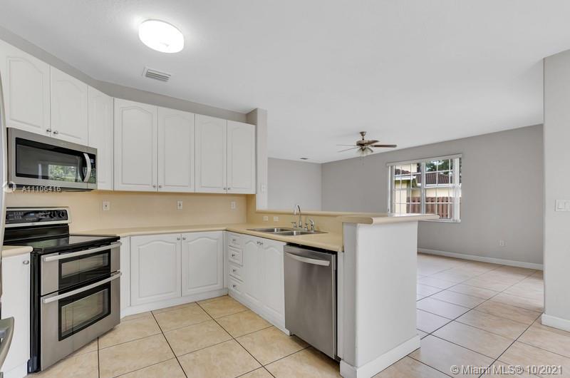 4131 Southwest 154th Court Miami, FL 33185 - Photo 7 of 36 a kitchen with granite countertop white cabinets stainless steel appliances and a window