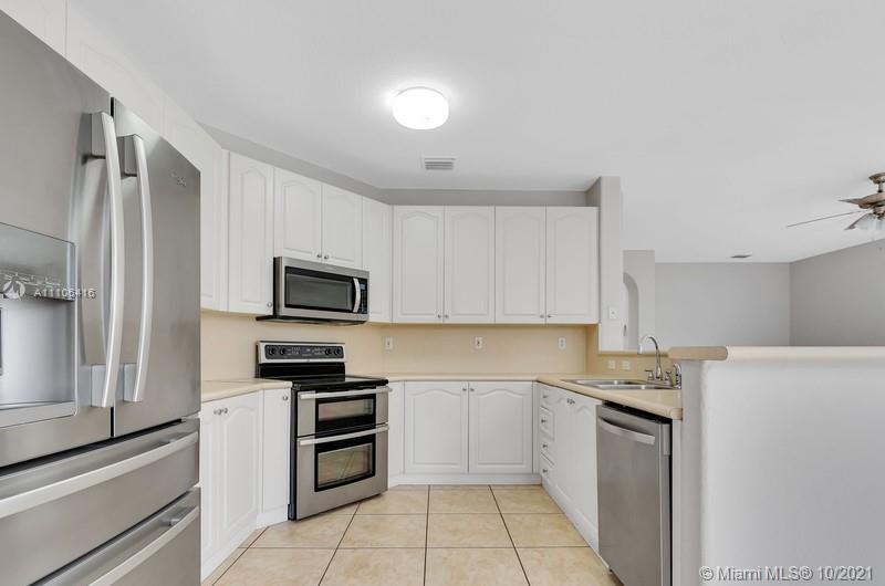 4131 Southwest 154th Court Miami, FL 33185 - Photo 8 of 36 a kitchen with a refrigerator stove and microwave
