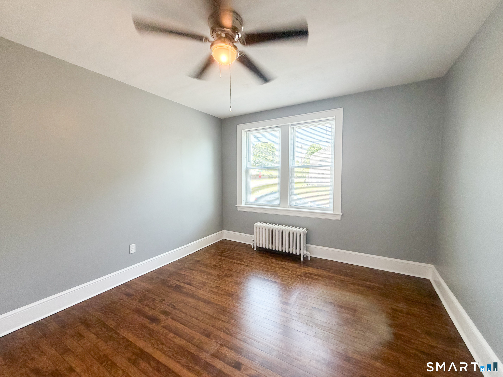 793 Milford Point Road, Unit 1 Milford, CT 06460 - Photo 12 of 16 an empty room with wooden floor and windows