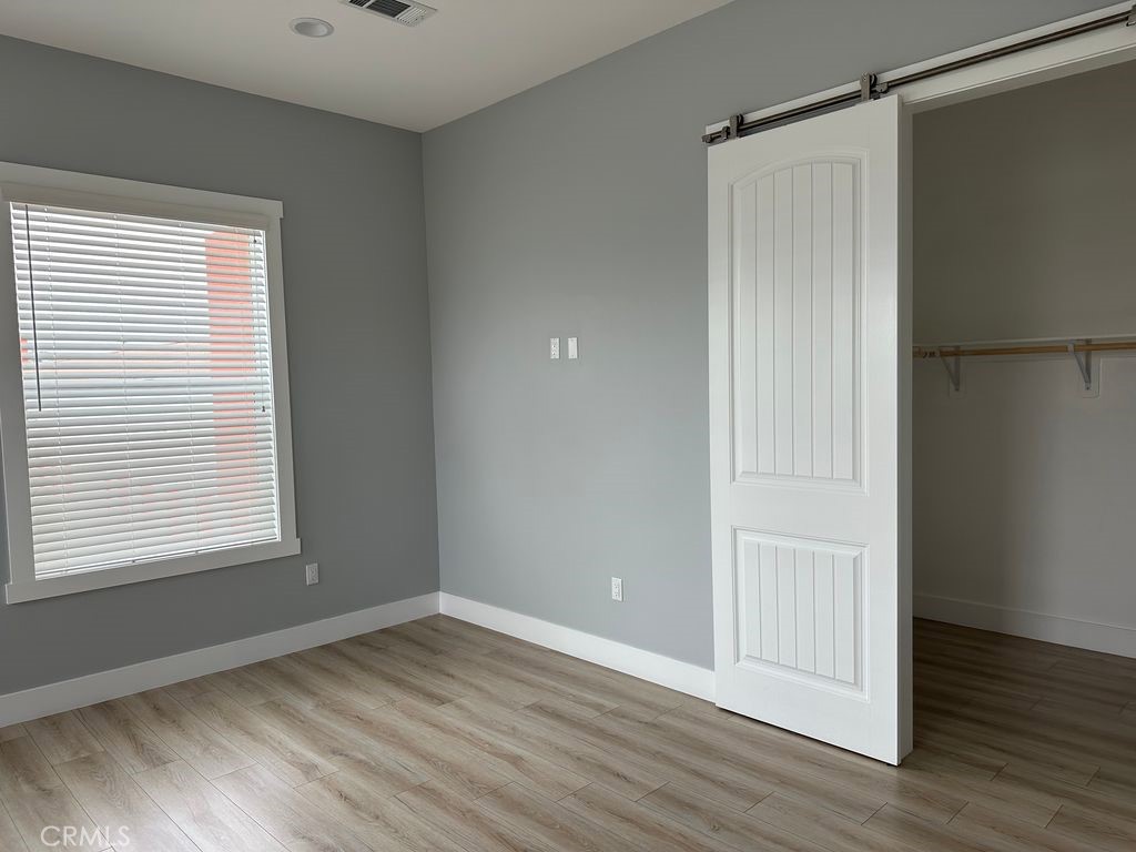 31913 St Joseph Lane Stanton, CA 90680 - Photo 12 of 12 a view of an empty room with wooden floor and a window