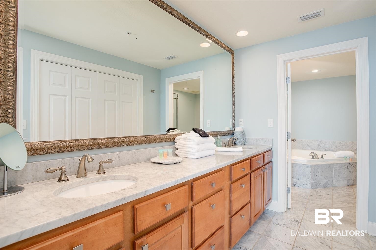 27800 Canal Road, Unit 411 Orange Beach, AL 36561 - Photo 23 of 49 Bathroom vanity featuring dual undermount sinks, stone countertop, brushed nickel fixtures, and wood cabinetry