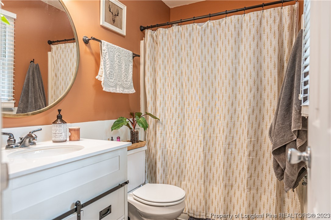 3 Red Cedar Lane Pinehurst, NC 28374 - Photo 11 of 20 a bathroom with a sink a toilet and shower curtain