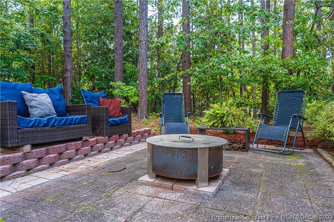 3 Red Cedar Lane Pinehurst, NC 28374 - Photo 17 of 20 a view of a patio with table and chairs potted plants and large tree