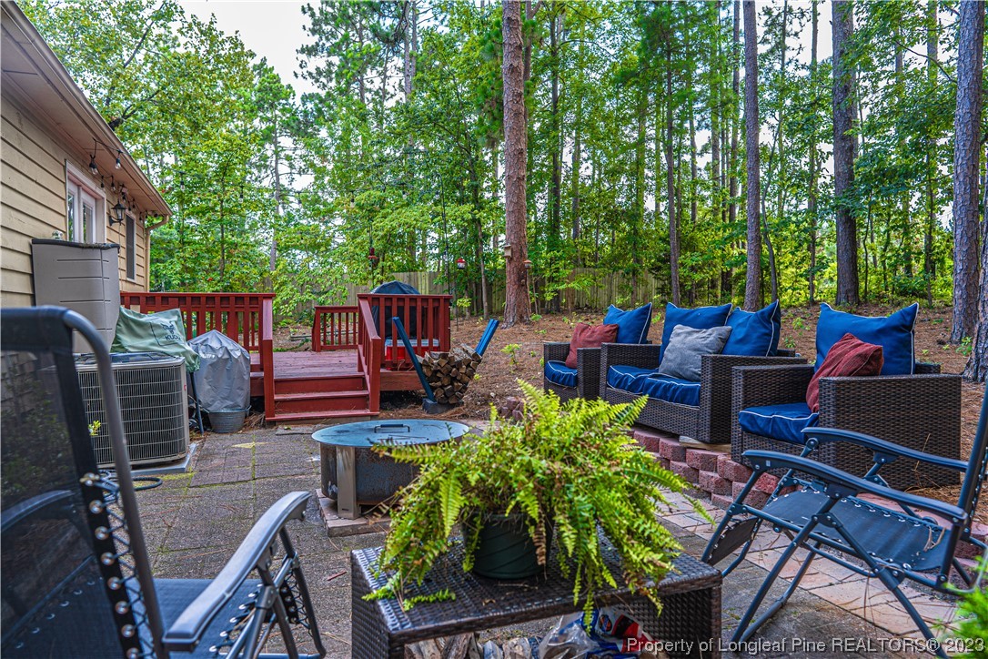 3 Red Cedar Lane Pinehurst, NC 28374 - Photo 18 of 20 a view of a patio with couches chairs potted plants and a large tree