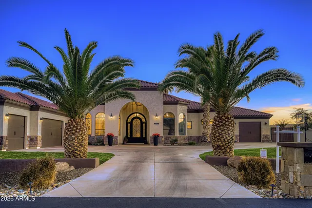 a view of a white house with a yard and potted plants
