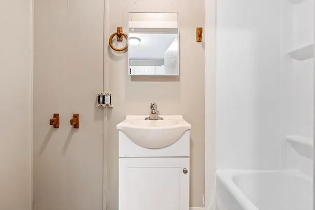 a kitchen with white cabinets and sink