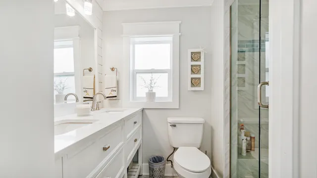a bathroom with a double vanity sink toilet and shower