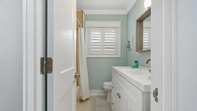a bathroom with a sink a toilet and a window