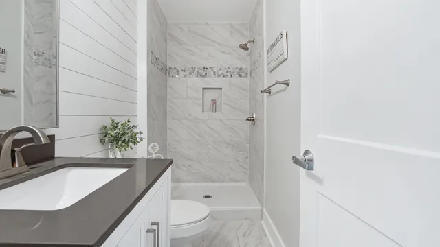 a bathroom with a granite countertop sink toilet and shower