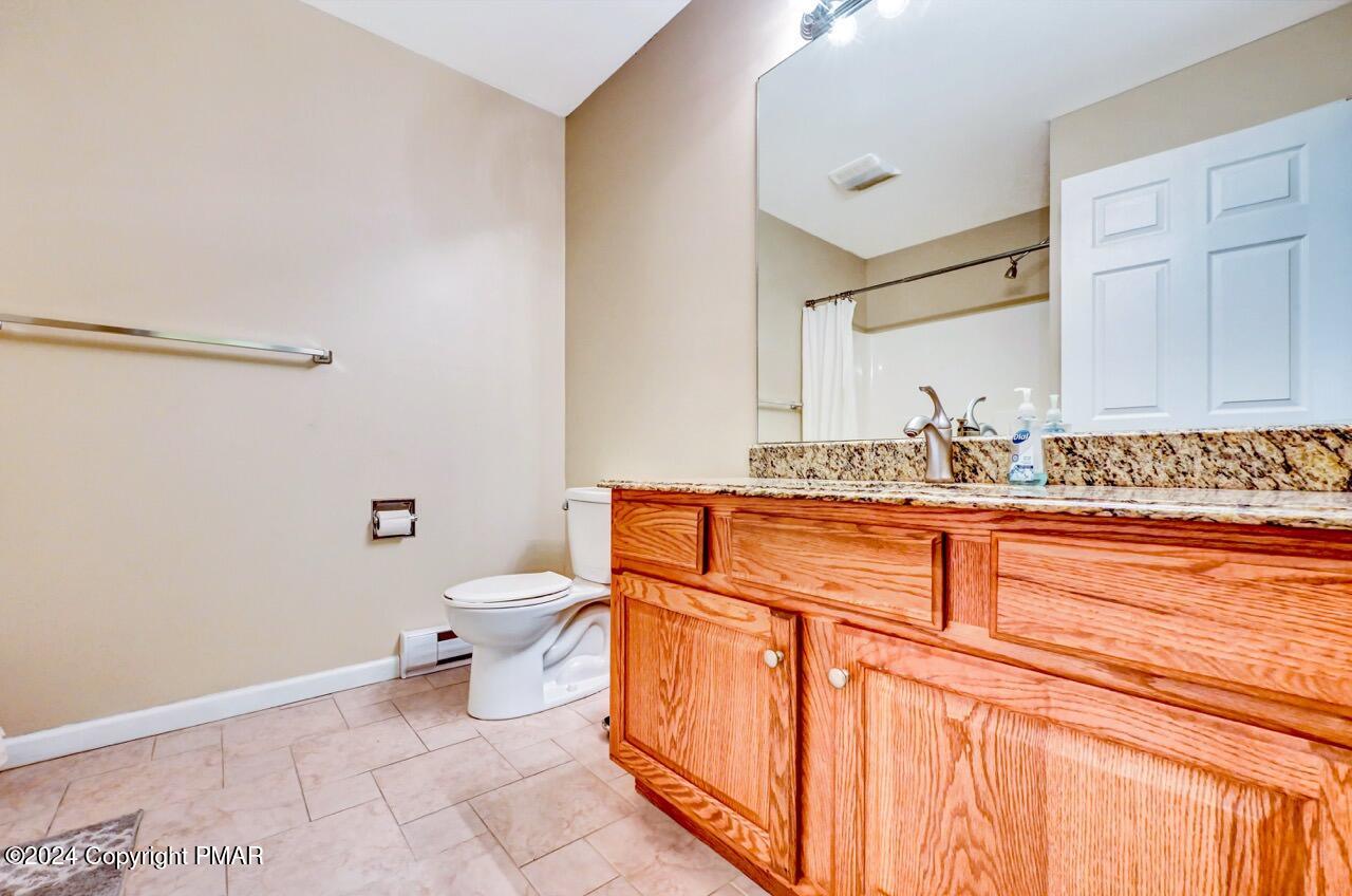 119 Woodland Road Albrightsville, PA 18210 - Photo 23 of 45 a bathroom with a granite countertop sink a toilet and a mirror