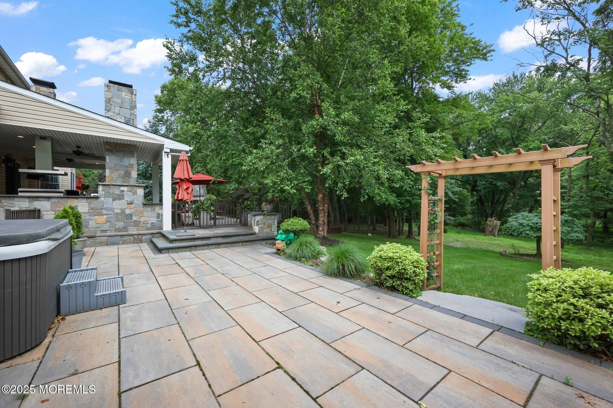 4 White Pines Way Freehold, NJ 07728 - Photo 63 of 66 a view of a patio with table and chairs potted plants and large tree