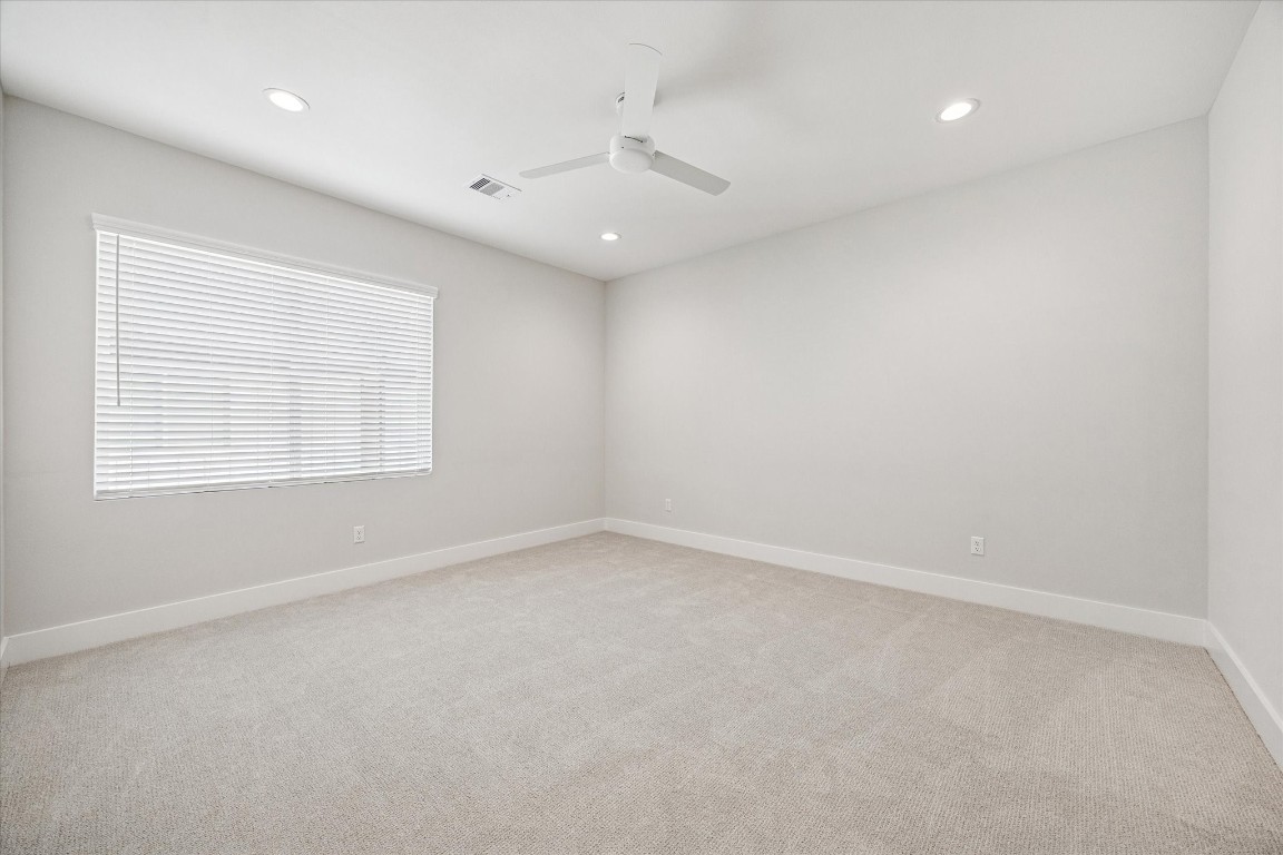 520 Janisch Road Houston, TX 77018 - Photo 14 of 28 The spacious primary suite features recessed lighting, a ceiling fan, a large window with window coverings, and a large walk-in closet with built-ins.