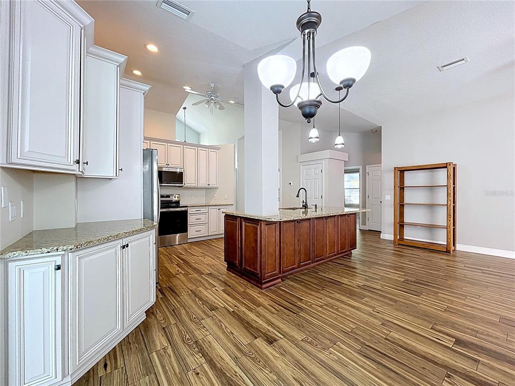 18812 Bascomb Lane Hudson, FL 34667 - Photo 27 of 57 a large kitchen with stainless steel appliances granite countertop a sink dishwasher a stove and a large kitchen island with wooden floor