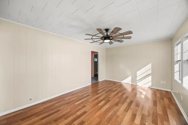 a view of empty room with wooden floor