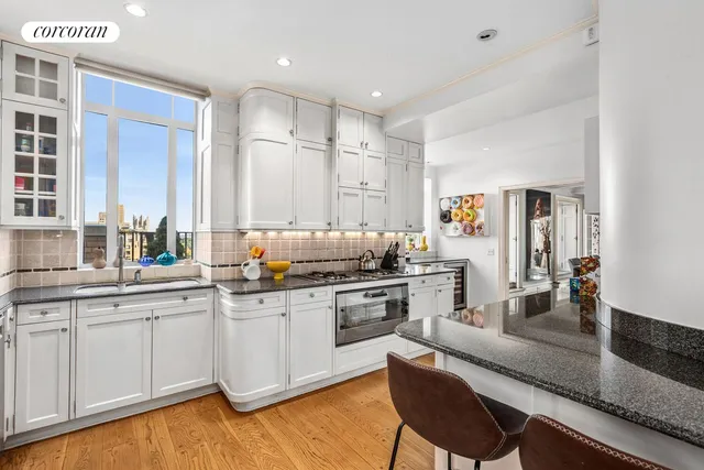 a kitchen with white cabinets and sink