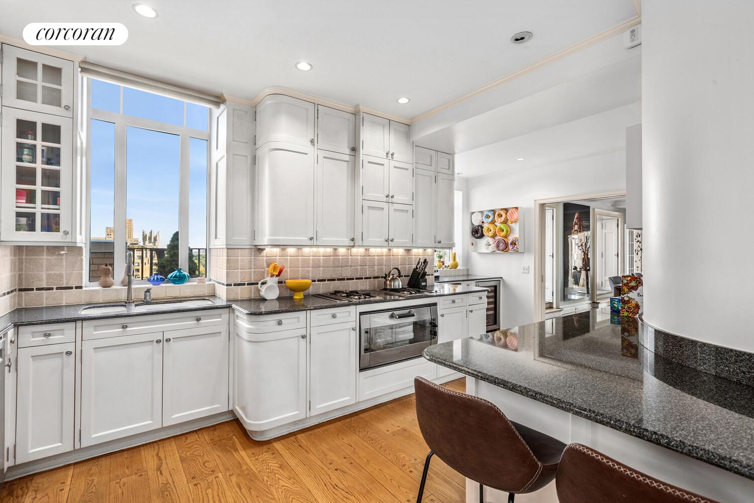 25 Central Park West, Unit 21Q Manhattan, NY 10023 - Photo 3 of 18 a kitchen with white cabinets and sink
