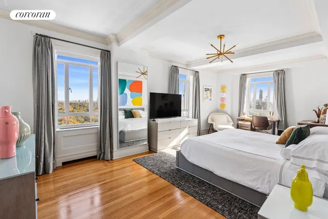 a bedroom with a bed a flat screen tv and a couch