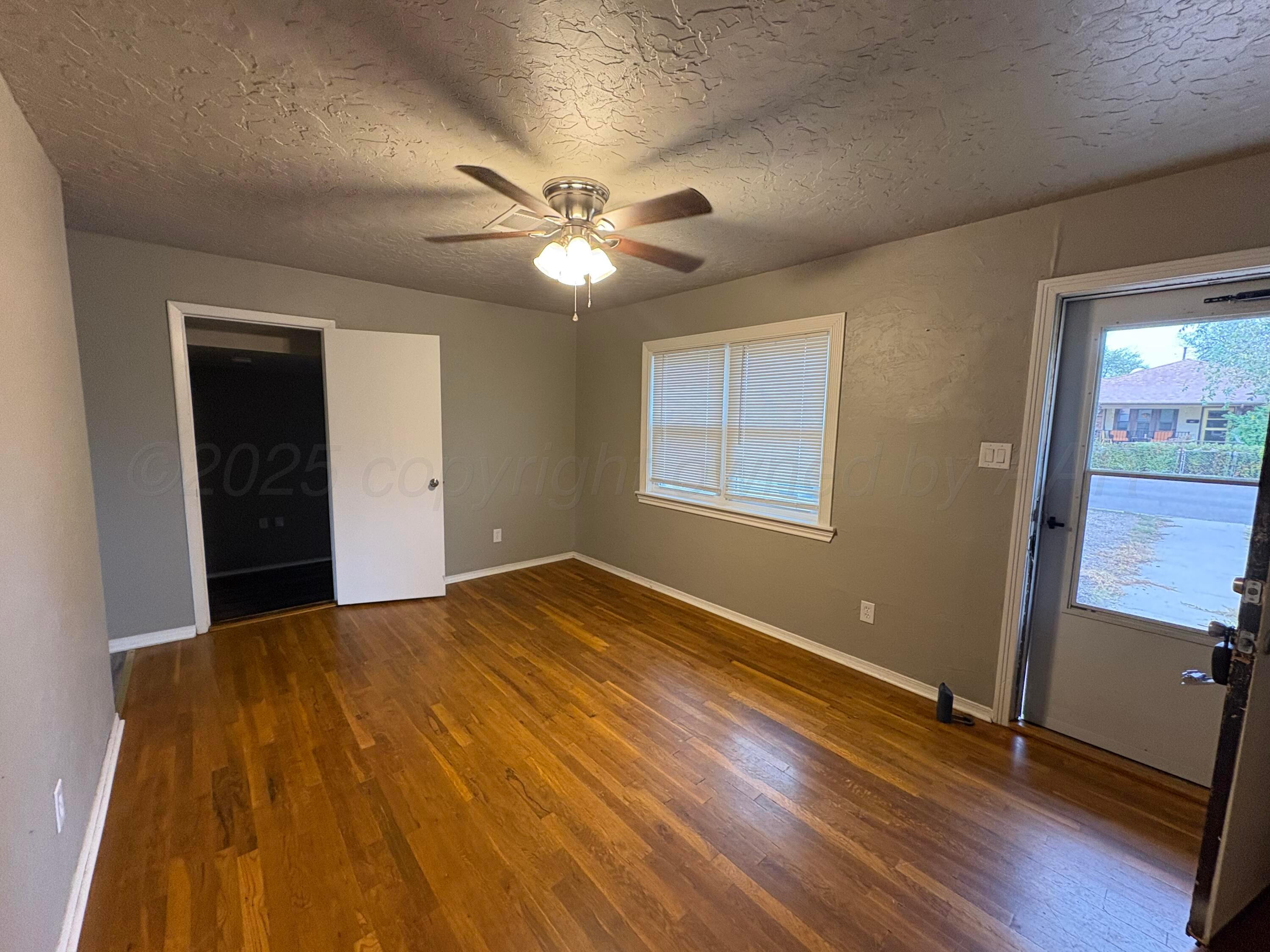 4514 South Bonham Street Amarillo, TX 79110 - Photo 2 of 10 a view of an empty room with a window and wooden floor