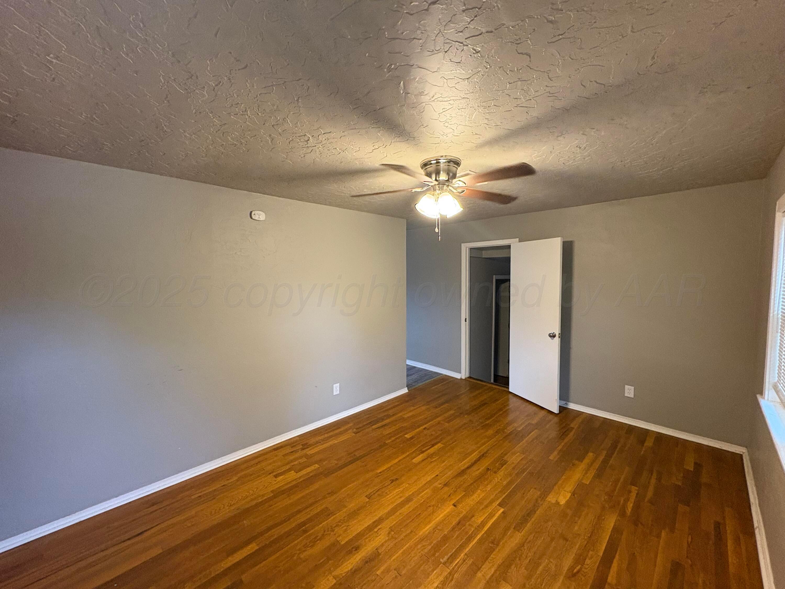 4514 South Bonham Street Amarillo, TX 79110 - Photo 3 of 10 a view of an empty room with wooden floor