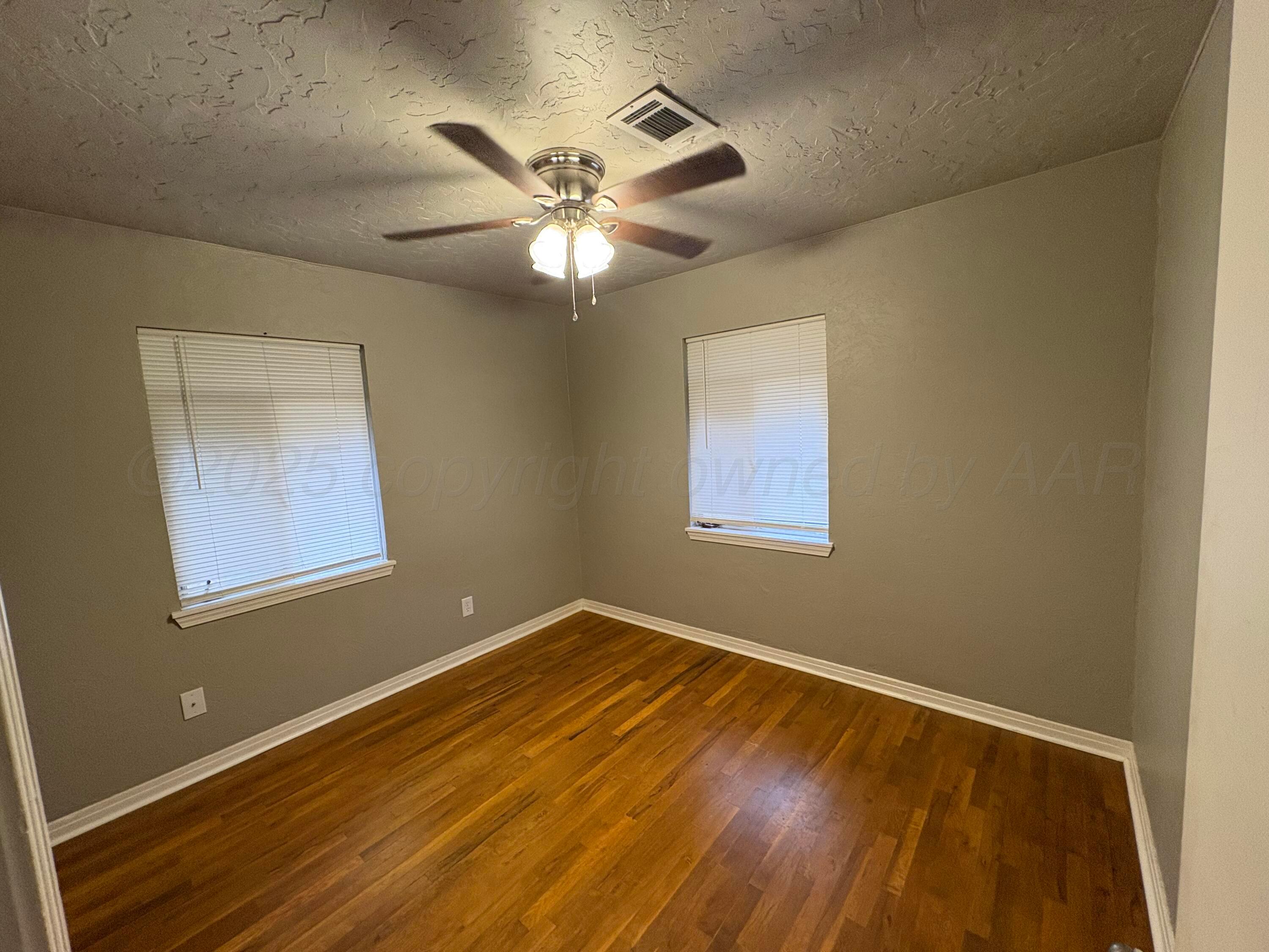 4514 South Bonham Street Amarillo, TX 79110 - Photo 7 of 10 a view of an empty room with wooden floor and a window
