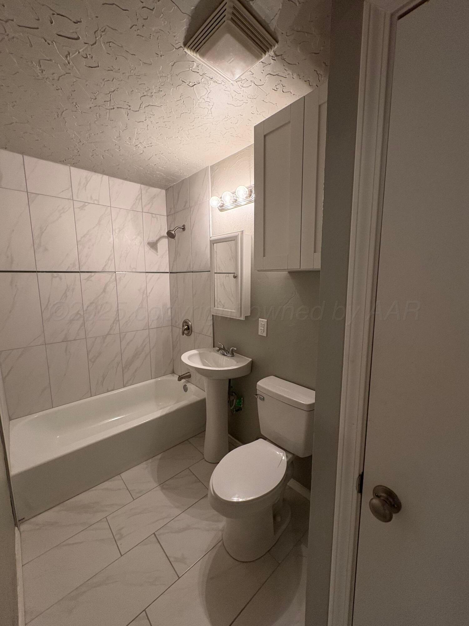 4514 South Bonham Street Amarillo, TX 79110 - Photo 9 of 10 a bathroom with a toilet a sink and bathtub