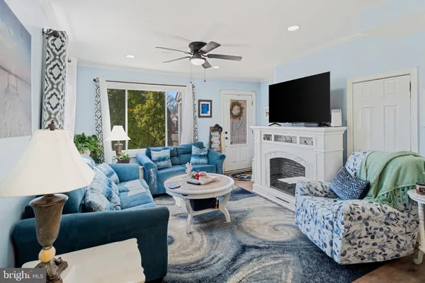 a living room with furniture a flat screen tv and a fireplace