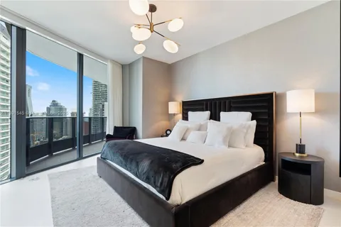 a bedroom with a large bed and a chandelier