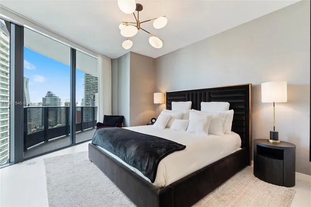 a bedroom with a large bed and a chandelier